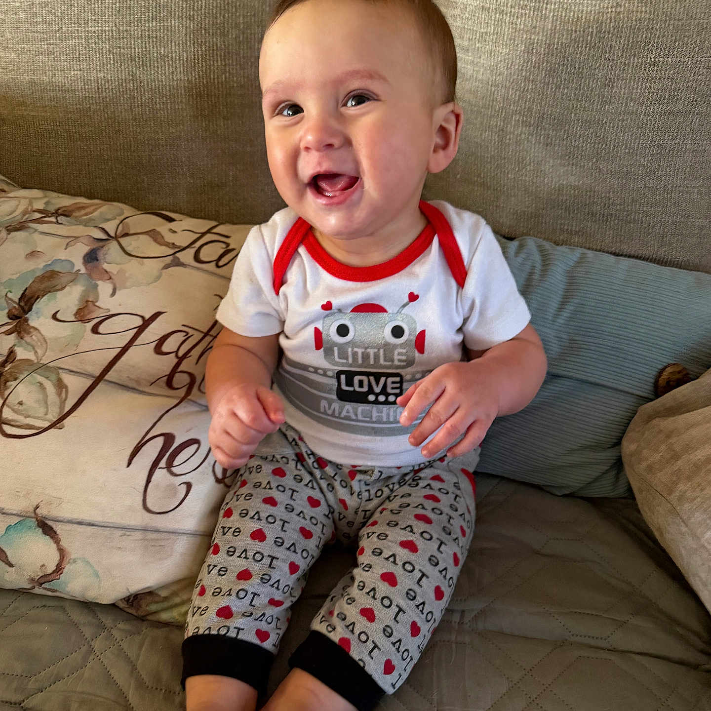 Ezra joined the competition — help win amazing prizes! baby, child, clothing, couch, cozy, cute, fabric, feet, happy, home, indoors, infant, love, pattern, person, pillow, portrait, robot, sitting, smiling