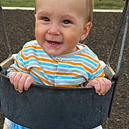 Ezra joined the competition — help win amazing prizes! toddler, child, swing, playground, outdoor, happy, smiling, clothing, striped_shirt, blue_pants, blanket, play, fun, baby, park, metal_swing, grass, fence, daylight, cute
