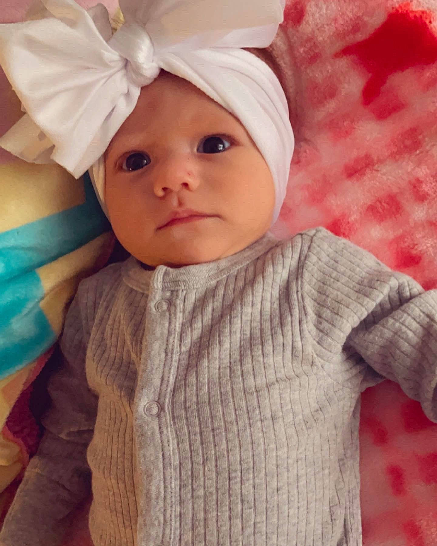 Xyla is registered to the contest to win money with this photo: baby, baby_toddler_clothing, cap, cool, costume_hat, dress, eye, face, happy, head, headgear, headwear, human_body, outerwear, person, pink, skin, sleeve, textile, toddler