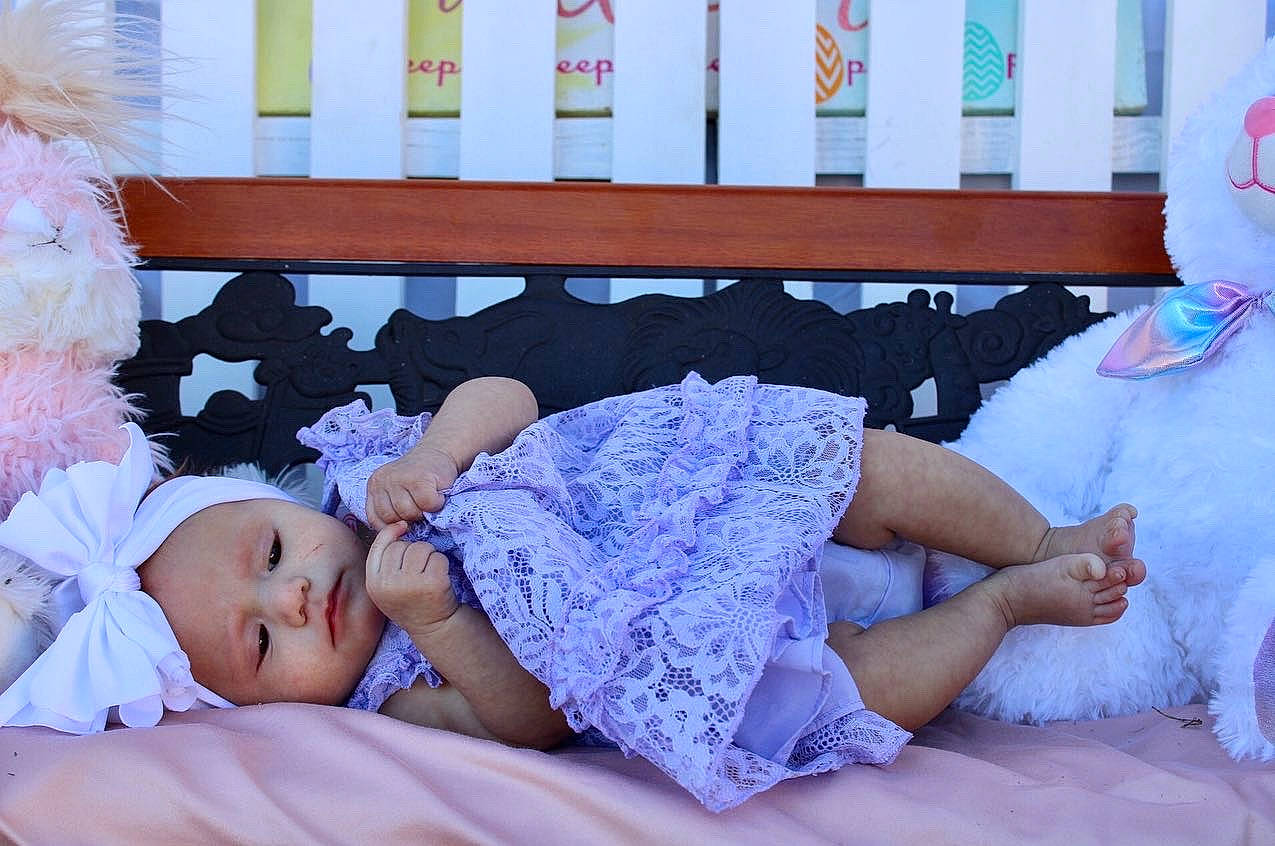 Xyla is registered to the contest to win money with this photo: arm, child, comfort, couch, dress, finger, hand, happy, headwear, human, human_body, leg, leisure, linens, organ, person, pink, purple, skin, summer