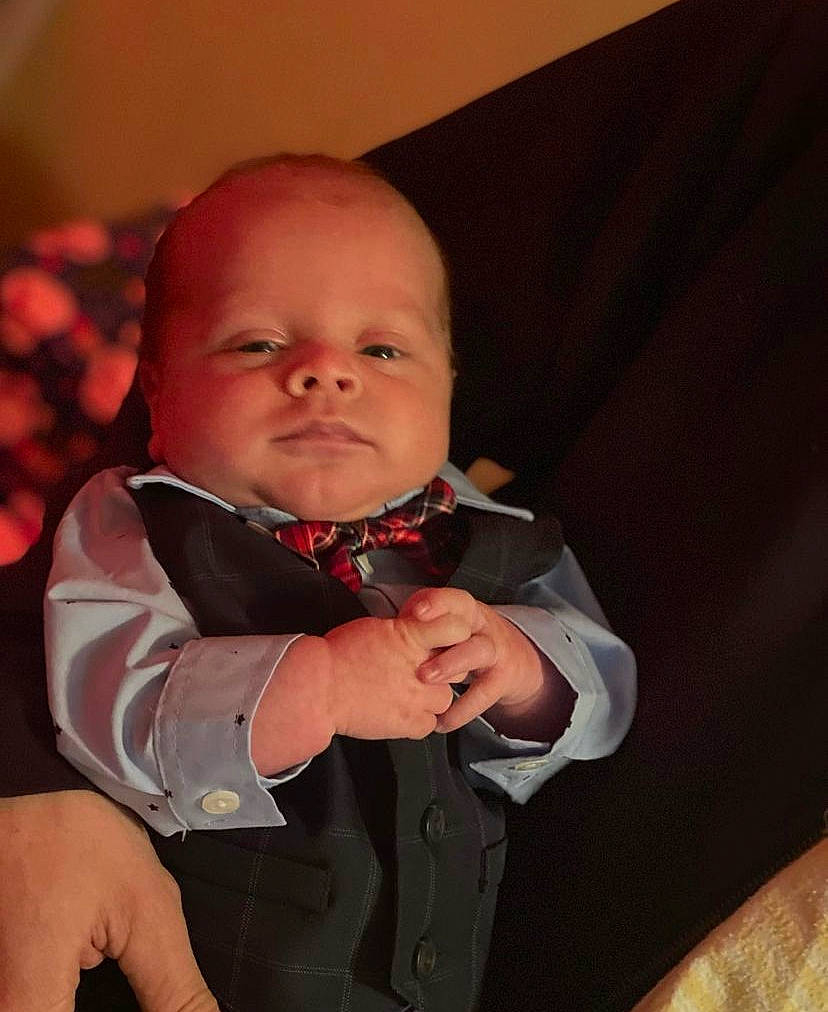 Brenden is registered to the contest to win money with this photo: arm, baby, baby_toddler_clothing, cheek, collar, comfort, event, eye, finger, flash_photography, formal_wear, gesture, hand, happy, person, skin, sleeve, suit, thumb, tie