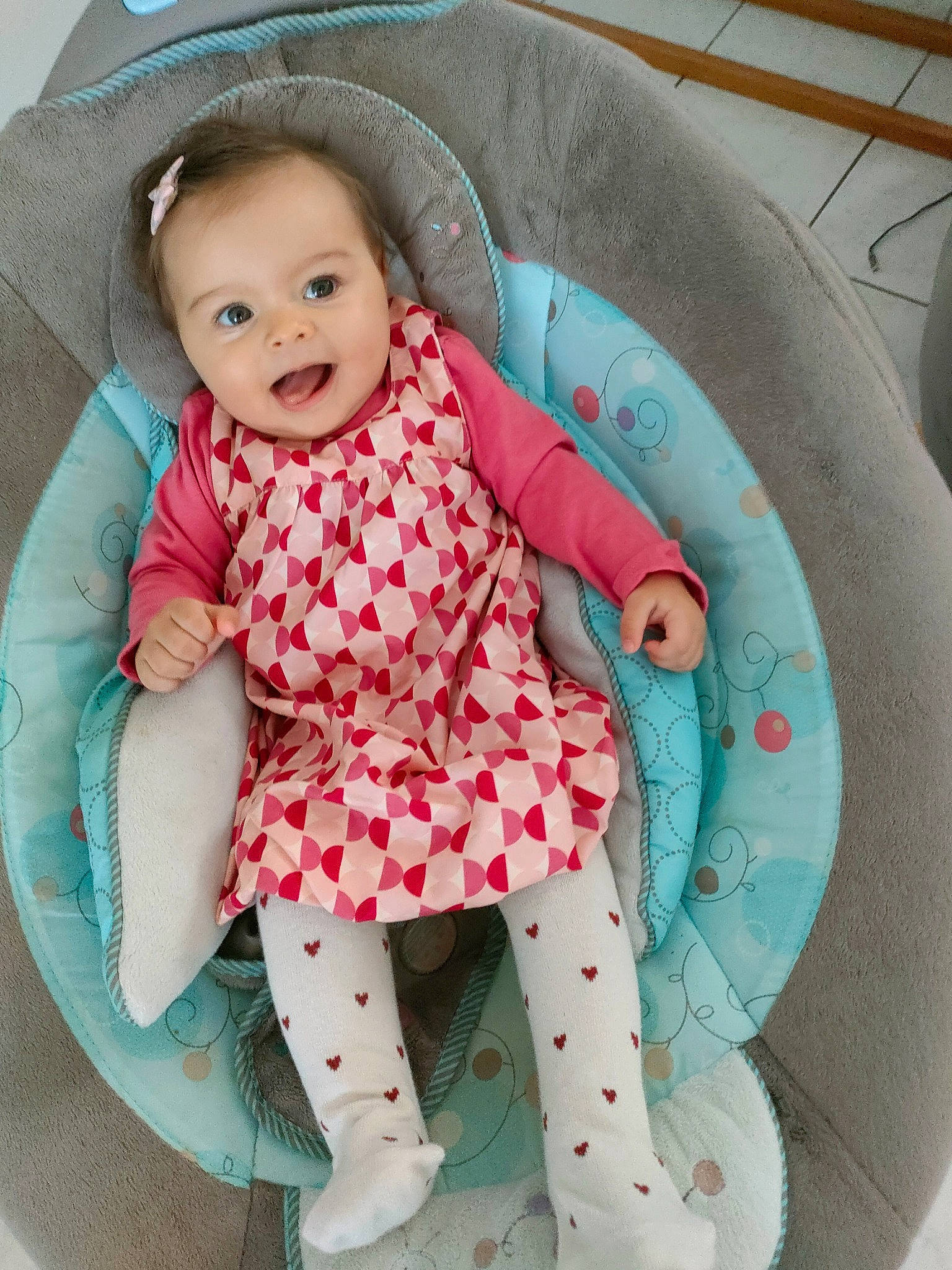 Ayana participe au concours pour gagner de l'argent avec cette photo : aqua, baby, baby_products, baby_toddler_clothing, car_seat, chair, child, comfort, fun, happy, linens, magenta, pattern, person, pink, product, sitting, sleeve, smile, thigh