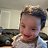 toddler, child, smile, curly_hair, indoor, living_room, couch, person, happy, baby_clothes, face, young_child, home, playful, cute, infant, portrait, furniture, casual, joyful