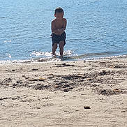 Andria a rejoint le concours — aidez-le/la à gagner de superbes lots ! barefoot, beach, boy, child, coast, daytime, holiday, nature, outdoor, playing, recreation, sand, shore, shorts, summer, sunlight, vacation, water, water_splash, waves