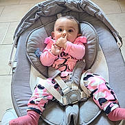Laetitia a rejoint le concours — aidez-le/la à gagner de superbes lots ! baby, infant, child, pink_clothing, baby_rocker, seatbelt, socks, thumb_sucking, floor_tile, white_shoe, indoor, curious_expression, seated, baby_girl, comfortable, casual, person, portrait, baby_toys, soft_fabric