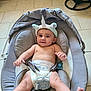 baby, infant, unicorn_headband, diaper, baby_seat, gray, tiled_floor, smiling, happy, cute, child, indoor, baby_boy, headwear, feet, arms, sitting, comfort, seatbelt, pacifier