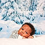 baby, infant, newborn, portrait, face, eyes, cheeks, hands, striped_shirt, blanket, bedding, snow, winter_scene, snowy_backdrop, evergreen_trees, studio_photo, cozy, adorable, laying_down, curly_hair