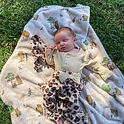 April is registered to the contest to win money with this photo: baby, sleeping, blanket, winnie_the_pooh, grass, outdoor, infant, clothing, patterned_pants, headband, nature, cute, peaceful, child, soft_texture, sunlight, portrait, person, resting, baby_girl