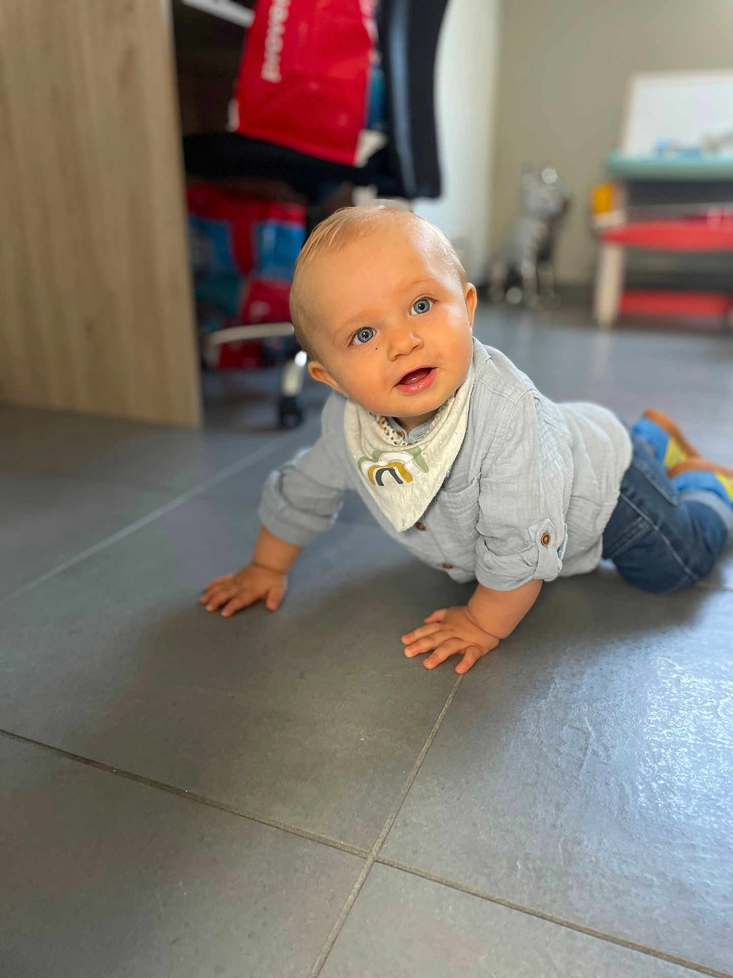 Aksel a rejoint le concours — aidez-le/la à gagner de superbes lots ! baby, child, crawling, floor, indoor, blue_eyes, shirt, jeans, bib, shoes, tiled_floor, home, furniture, blurred_background, person, cute, smiling, hands, head, portrait
