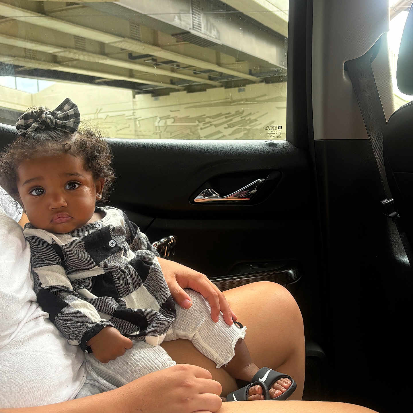 Adore joined the competition — help win amazing prizes! black_and_white_clothing, bow, car_interior, casual, child, curly_hair, daylight, door_handle, hand, indoors, lap, legs, person, portrait, sandals, seatbelt, sitting, skin, toddler, window