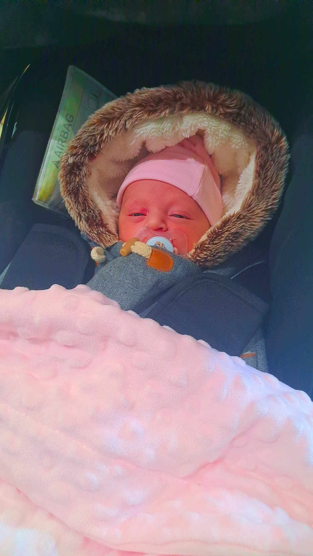 Célia a rejoint le concours — aidez-le/la à gagner de superbes lots ! newborn, baby, pacifier, blanket, car_seat, fur_hood, pink_hat, sleepy, infant, child, cozy, warm, soft_texture, closeup, portrait, indoors, airbag_tag, clothing, cute, person