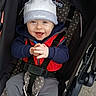 baby, child, smiling, hat, jacket, stroller, seatbelt, clothing, hands, happy, face, person, outdoor, polka_dot, fabric, baby_wear, casual, cute, blue_eyes, infant