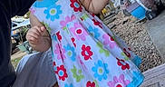Mia is registered to the contest to win money with this photo: child, toddler, baby, girl, portrait, smiling, outdoor, porch, garden, dress, floral_dress, green_bow, white_shoes, standing, reaching, hands, adult, plants, gravel, snapchat_filter