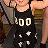 Mia is registered to the contest to win money with this photo: baby, child, infant, smiling, happy, portrait, standing, arms_raised, black_outfit, ghost_pattern, costume, clothing, indoor, home, adults, hands, chair, carpet, flash_photography, family
