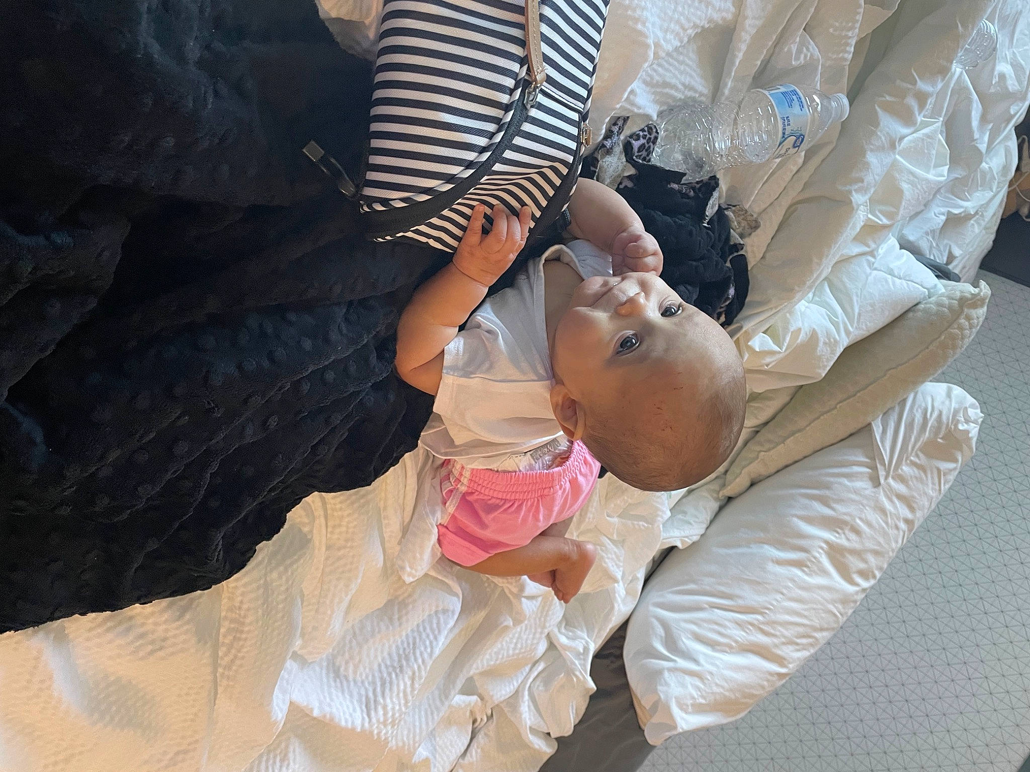 Joy is registered to the contest to win money with this photo: baby, baby_products, bridal_accessory, child, comfort, dress, elbow, event, finger, gesture, hand, happy, hat, human_body, leg, linens, nail, person, sitting, skin