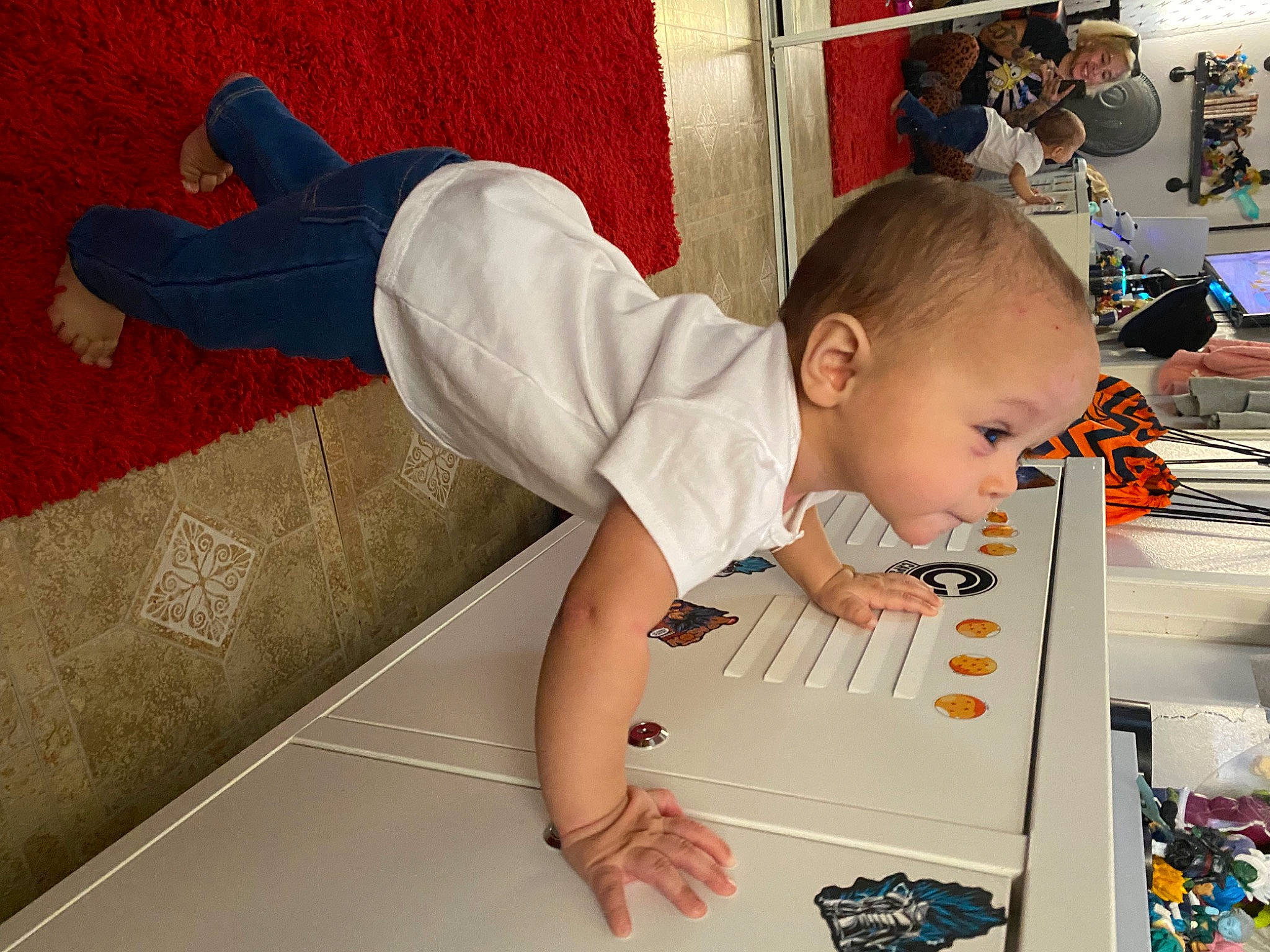 Joy is registered to the contest to win money with this photo: baby, baby_toddler_clothing, carmine, child, comfort, eyewear, flooring, foot, fun, happy, hardwood, human_leg, joy, person, play, room, sitting, sleeve, sock, t_shirt