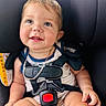baby, child, infant, smiling, happy, portrait, car_seat, safety_harness, vehicle, automobile, indoors, seated, blond_hair, blue_eyes, baby_clothing, red_buckle, close_up, photography, face, safe_travel