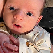 Kaysen is registered to the contest to win money with this photo: baby, infant, face, hands, clothing, onesie, cute, expression, portrait, skin, eyes, person, newborn, young_child, indoor, closeup, human, baby_garment, child, small_hands