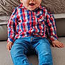 Marceau a rejoint le concours — aidez-le/la à gagner de superbes lots ! baby, child, smiling, blue_eyes, plaid_shirt, jeans, socks, sitting, couch, blanket, indoor, happy, cute, face, portrait, young_child, casual_clothing, home, comfort, cozy