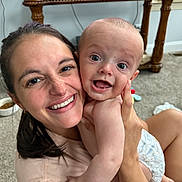 James joined the competition — help win amazing prizes! baby, candid, carpet, child, closeup, diaper, expression, face, family, happy, holding, indoor, joy, parent, person, skin, smile, table, television, woman