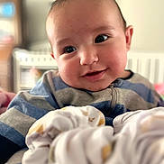 Cash King Caples joined the competition — help win amazing prizes! baby, infant, child, smiling, portrait, face, eyes, indoors, nursery, crib, blanket, clothing, striped_shirt, couch, soft_focus, close_up, happy, head, furniture, photograph