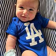 Cash is registered to the contest to win money with this photo: baby, child, infant, smiling, portrait, blue_shirt, striped_chair, sitting, indoors, face, eyes, hair, arms, legs, sock, clothing, happy, close_up, casual, photography