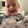 Cash joined the competition — help win amazing prizes! baby, infant, child, smiling, laughing, portrait, face, eyes, indoors, nursery, crib, blanket, bed, clothing, striped_shirt, cozy, happy, sitting, closeup, photograph