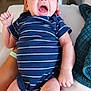 arm, baby, bed, blanket, care, clothing, face, hand, hospital, indoor, infant, leg, lying_down, medical_wires, newborn, person, skin, striped_onesie, toddler, yawning