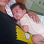 Sophia is registered to the contest to win money with this photo: baby, infant, adult, hospital, nasal_tube, cartoon_shirt, close_up, person, medical, bedroom, furniture, hand, face, clothing, healthcare, patient, resting, indoor, care, holding