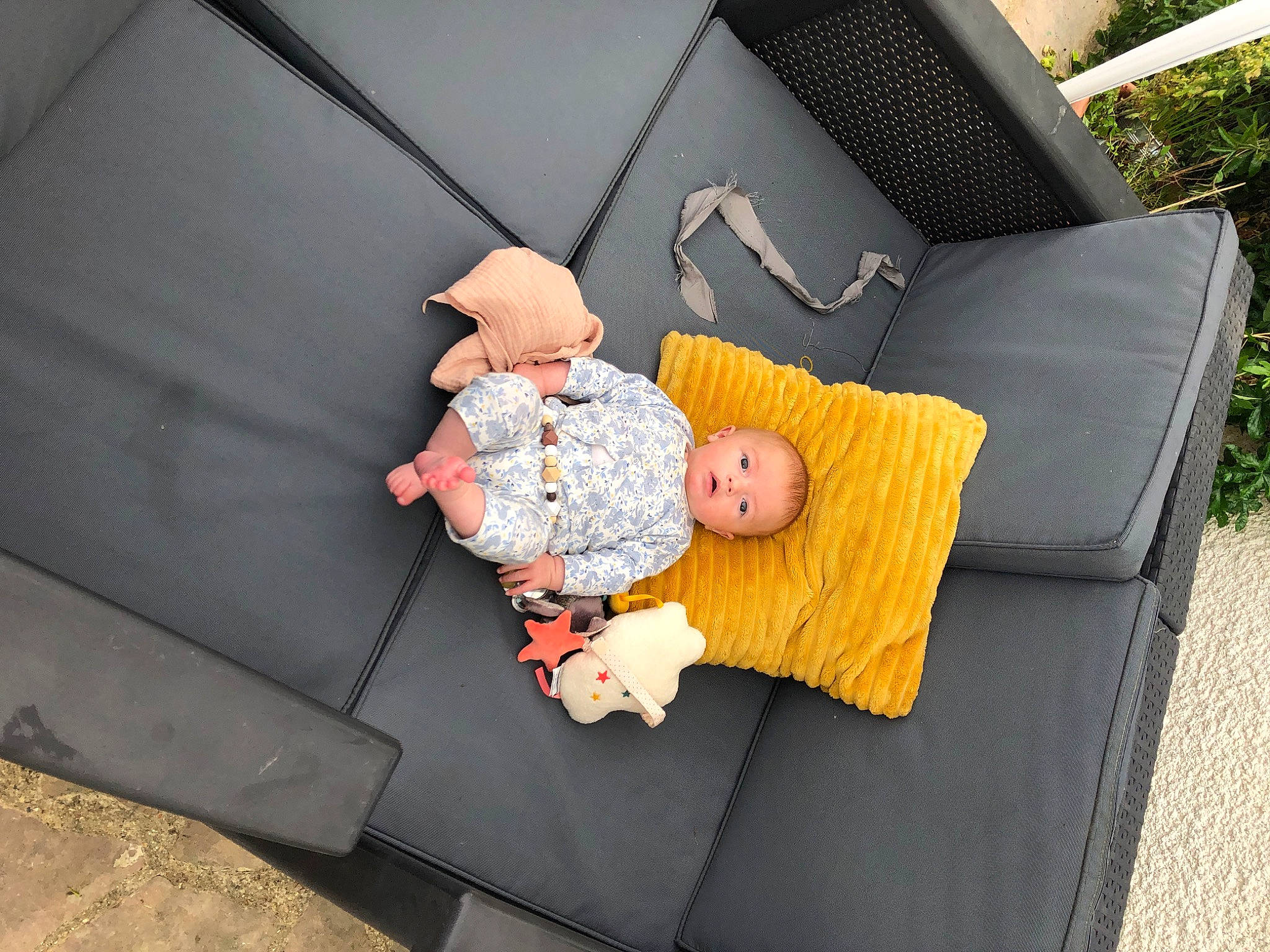 Lia participe au concours pour gagner de l'argent avec cette photo : baby_products, baby_toys, child, comfort, couch, flooring, grass, leisure, linens, luxury_vehicle, outdoor_furniture, person, plant, room, sitting, stuffed_toy, toddler, toy, vacation, wood