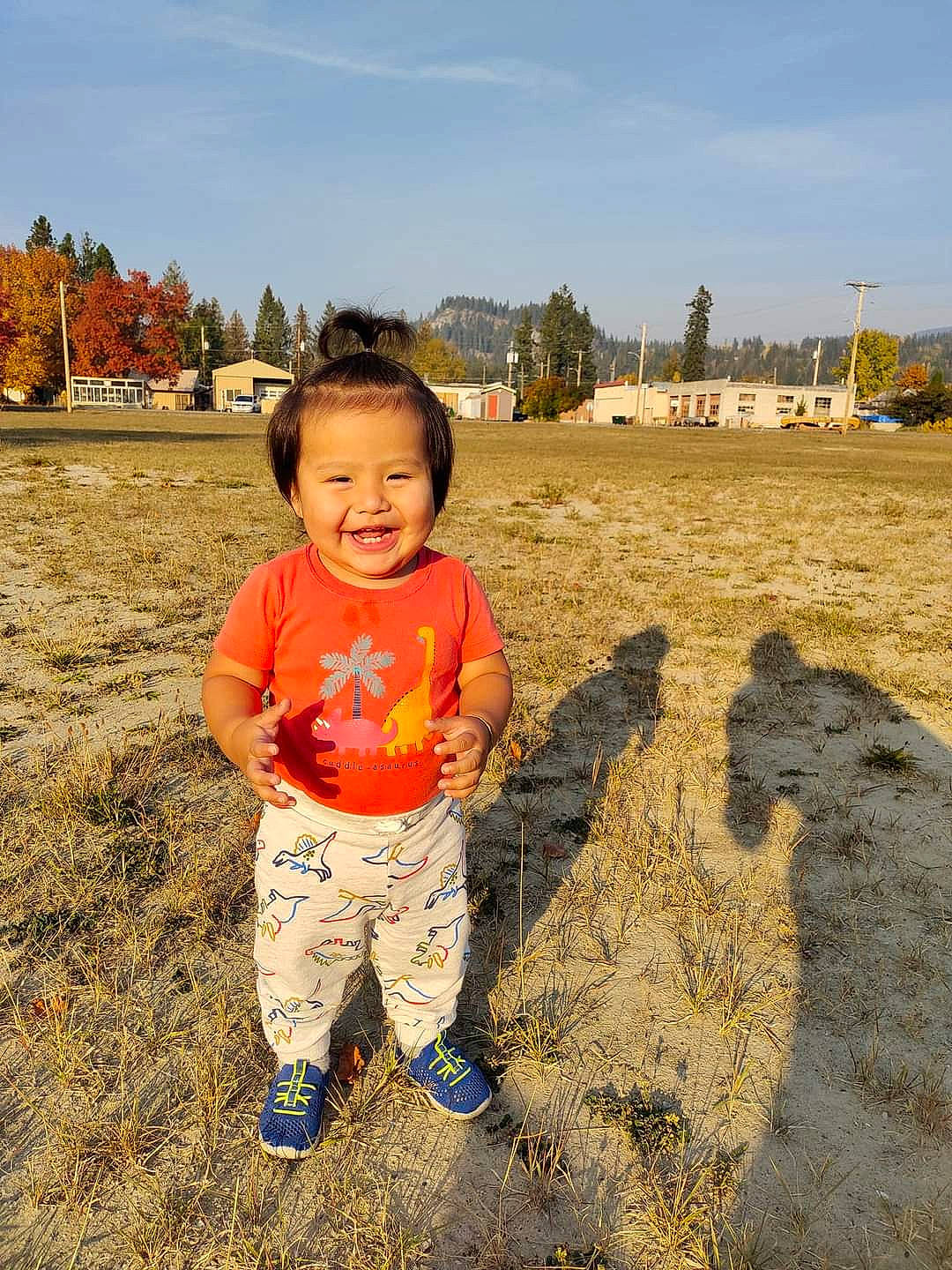 Leroy is registered to the contest to win money with this photo: baby_toddler_clothing, cloud, field, fun, grass, grassland, happy, horizon, joy, landscape, people_in_nature, person, plain, sand, sitting, sky, smile, soil, toddler, travel