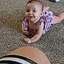 baby, child, infant, carpet, floor, person, leg, clothing, pink_outfit, cartoon_prints, smile, happy, indoor, candid, portrait, cute, young_child, toddler, lying_down, curious