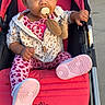 Legacy is registered to the contest to win money with this photo: animal_print, baby, casual_clothing, child, curly_hair, cute, daylight, expression, hand, hoodie, leggings, outdoor, pacifier, person, pink_shoes, seated, sidewalk, stroller, toddler, toy