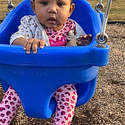 Legacy is registered to the contest to win money with this photo: baby, blue_swing, child, curly_hair, cute, daylight, expression, face, holding, jacket, leggings, outdoor, park, person, pink_clothing, playground, swing, toddler, trees, wood_chips
