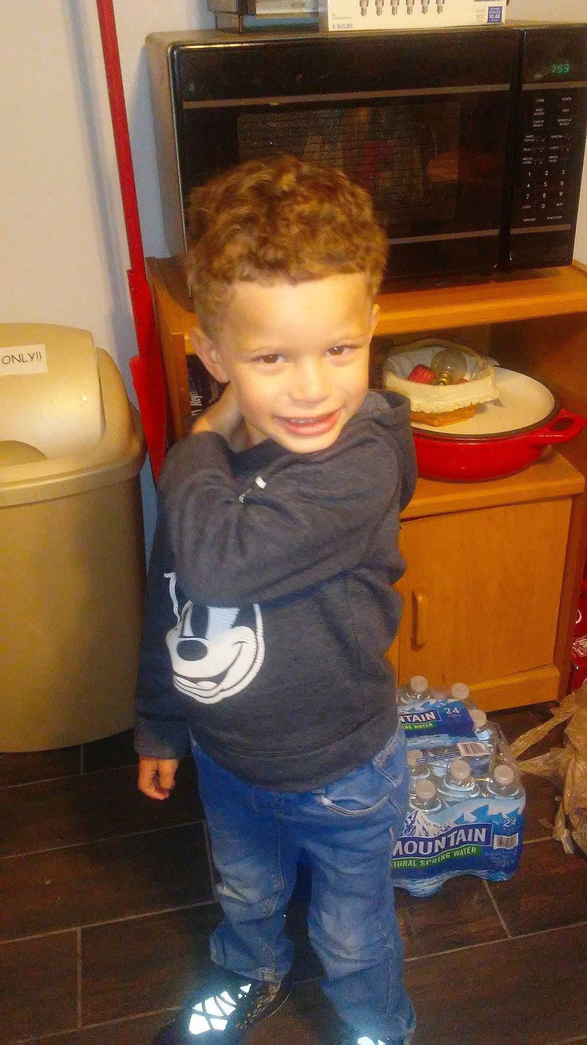 Kareem is registered to the contest to win money with this photo: baby, baby_toddler_clothing, baked_goods, box, cabinetry, child, joy, kitchen_appliance, microwave_oven, oven, person, shelf, shelving, shipping_box, snack, toddler