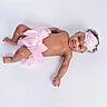 Alaiya joined the competition — help win amazing prizes! baby, infant, smile, pink_tutu, headband, flower, bow, bare_skin, lying_down, white_background, cute, child, portrait, adorable, happy, toddler, fashion, studio_photo, young_child, female