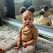 Kaylen is registered to the contest to win money with this photo: toddler, child, mirror, reflection, carpet, indoor, curly_hair, pigtails, leopard_print, pants, brown_shirt, sitting, barefoot, cute, expression, window, natural_light, room, wall, flooring