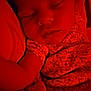 baby, sleeping, infant, red_light, blanket, floral_clothing, peaceful, closeup, face, portrait, resting, soft, cute, child, indoors, cozy, young, toddler, relaxing, nap