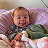 Ellie joined the competition — help win amazing prizes! baby, blanket, smiling, tongue_out, indoor, cushion, person, child, cozy, purple, green_blanket, floral_pattern, cute, happy, portrait, infant, soft, warm, comfort, resting