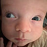 Myles joined the competition — help win amazing prizes! baby, blue_eyes, child, close_up, clothing, curious, eyelashes, eyes, face, fair_skin, hand, headshot, indoor, infant, looking_away, onesie, photography, portrait, rosy_cheeks, serious_expression