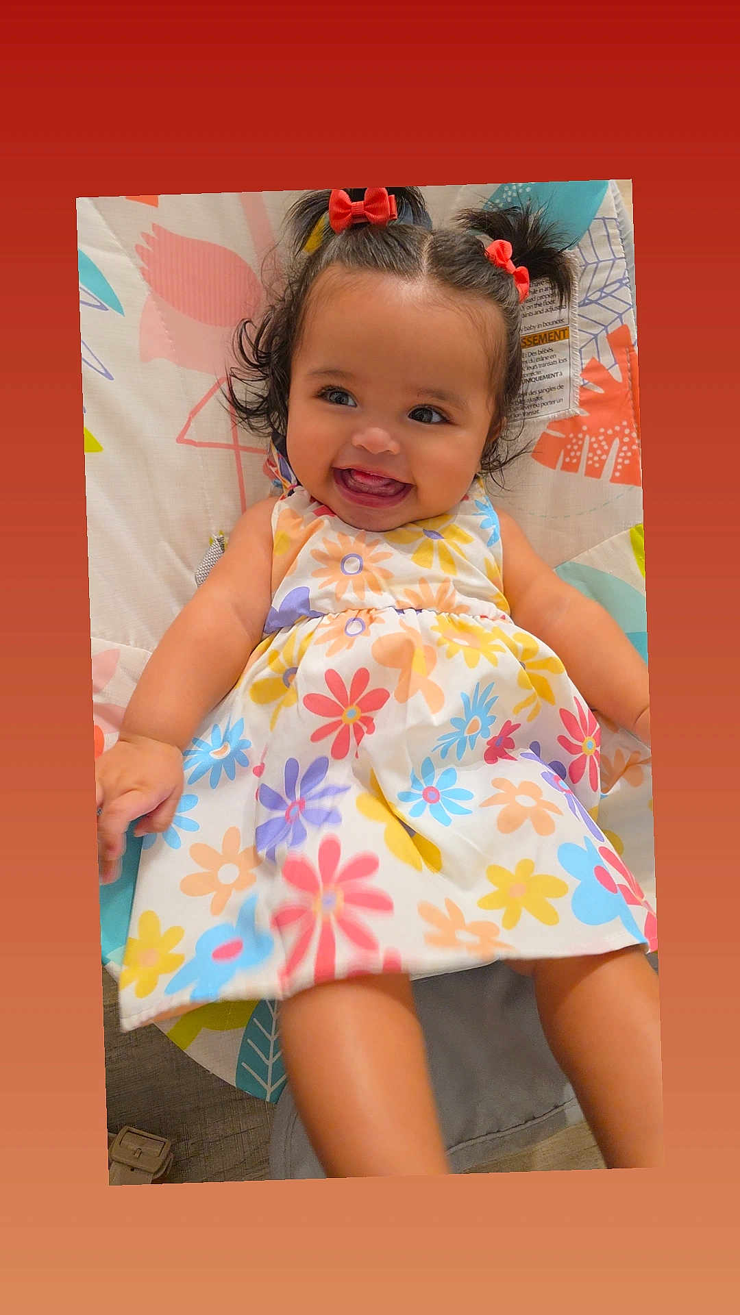 Elaine joined the competition — help win amazing prizes! baby, child, smiling, pigtails, red_bows, flower_dress, colorful, playmat, happy, cute, infant, portrait, indoors, skin, face, hands, legs, sitting, person, toddler