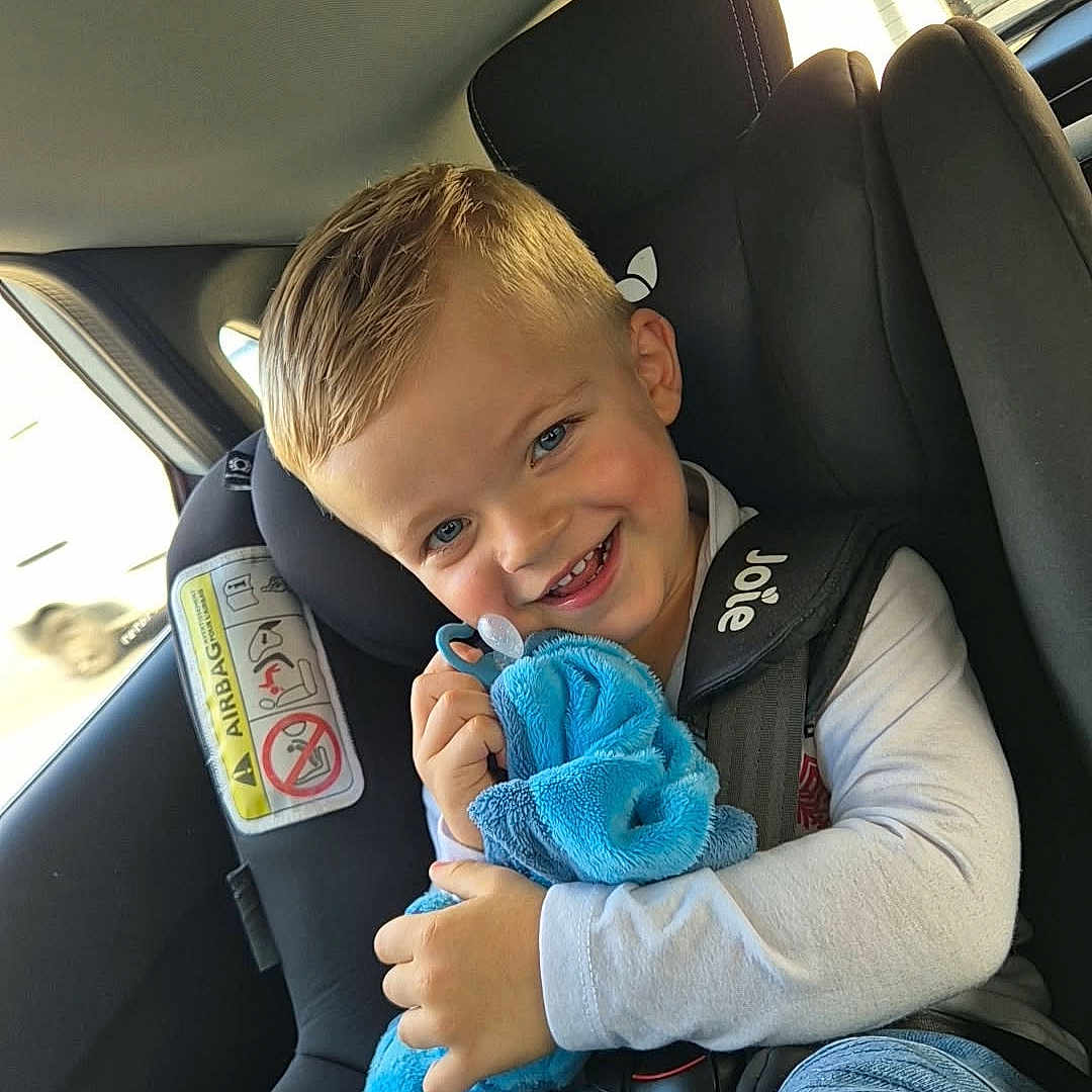 Kéloann a rejoint le concours — aidez-le/la à gagner de superbes lots ! blonde_hair, blue_eyes, blue_toy, boy, car_interior, car_seat, casual_clothing, child, child_safety_seat, cute, happy, indoor, jeans, long_sleeve_shirt, plush_toy, portrait, safety, seatbelt, smiling, travel