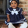 baby, child, sailor_outfit, hat, navy_blue, white_bow, brick_wall, fireplace, sitting, cute, smiling, indoors, portrait, footwear, white_shoes, curly_hair, infant, happy, person, young_child