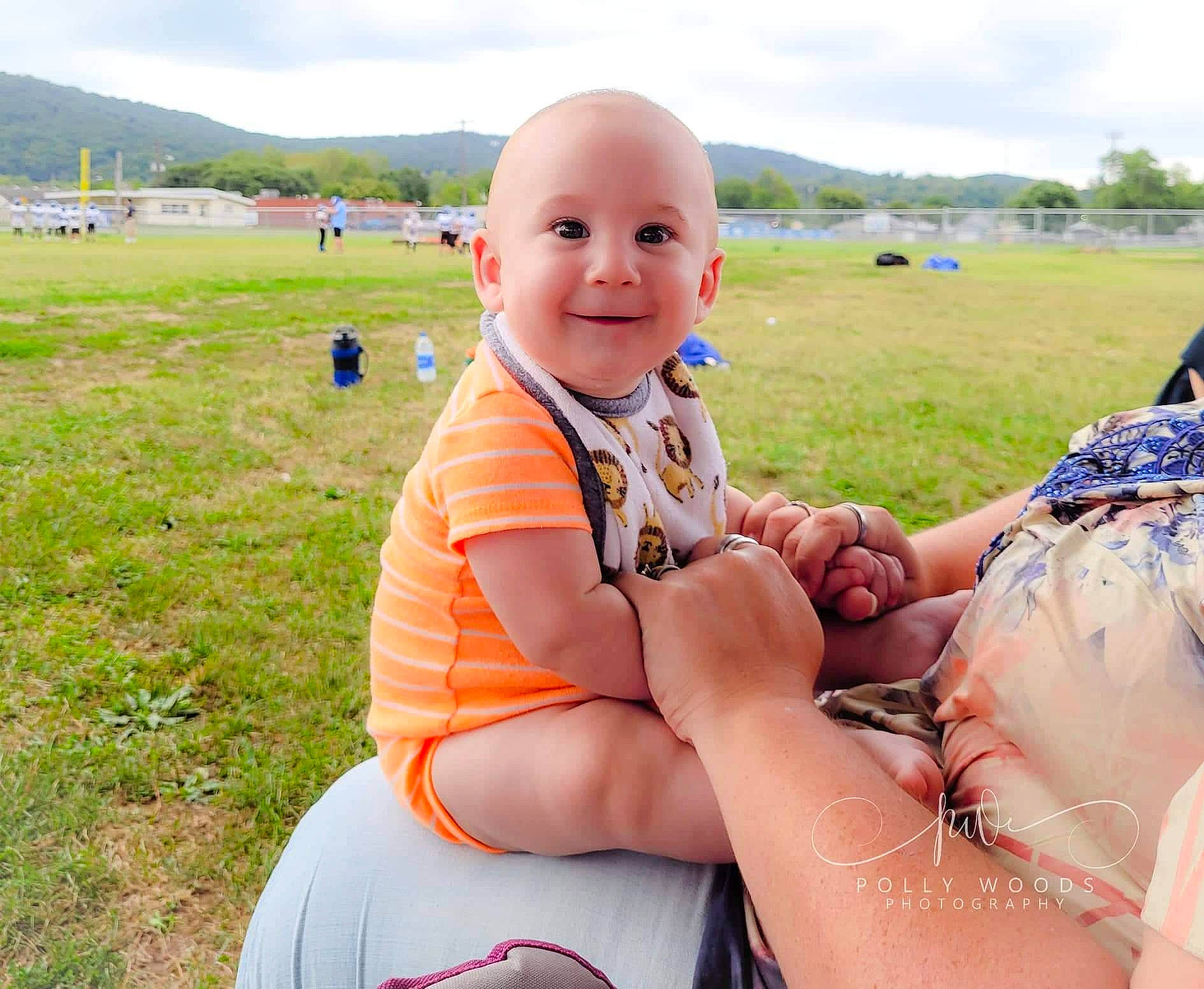 Brantlee is registered to the contest to win money with this photo: arm, baby, cloud, fun, grass, grassland, happy, joy, landscape, leg, leisure, meadow, people_in_nature, person, recreation, shorts, sky, smile, summer, thigh