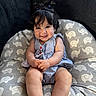 baby, child, smile, curly_hair, pigtails, cushion, elephant_pattern, blue_dress, indoors, happy, cute, sitting, infant, person, skin, legs, hands, face, portrait, cozy
