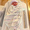 Malachi joined the competition — help win amazing prizes! newborn, baby, hospital, bassinet, blanket, hat, sleeping, infant, wrapped, striped, wooden_floor, peaceful, child, bed, healthcare, soft, cute, portrait, person, indoors