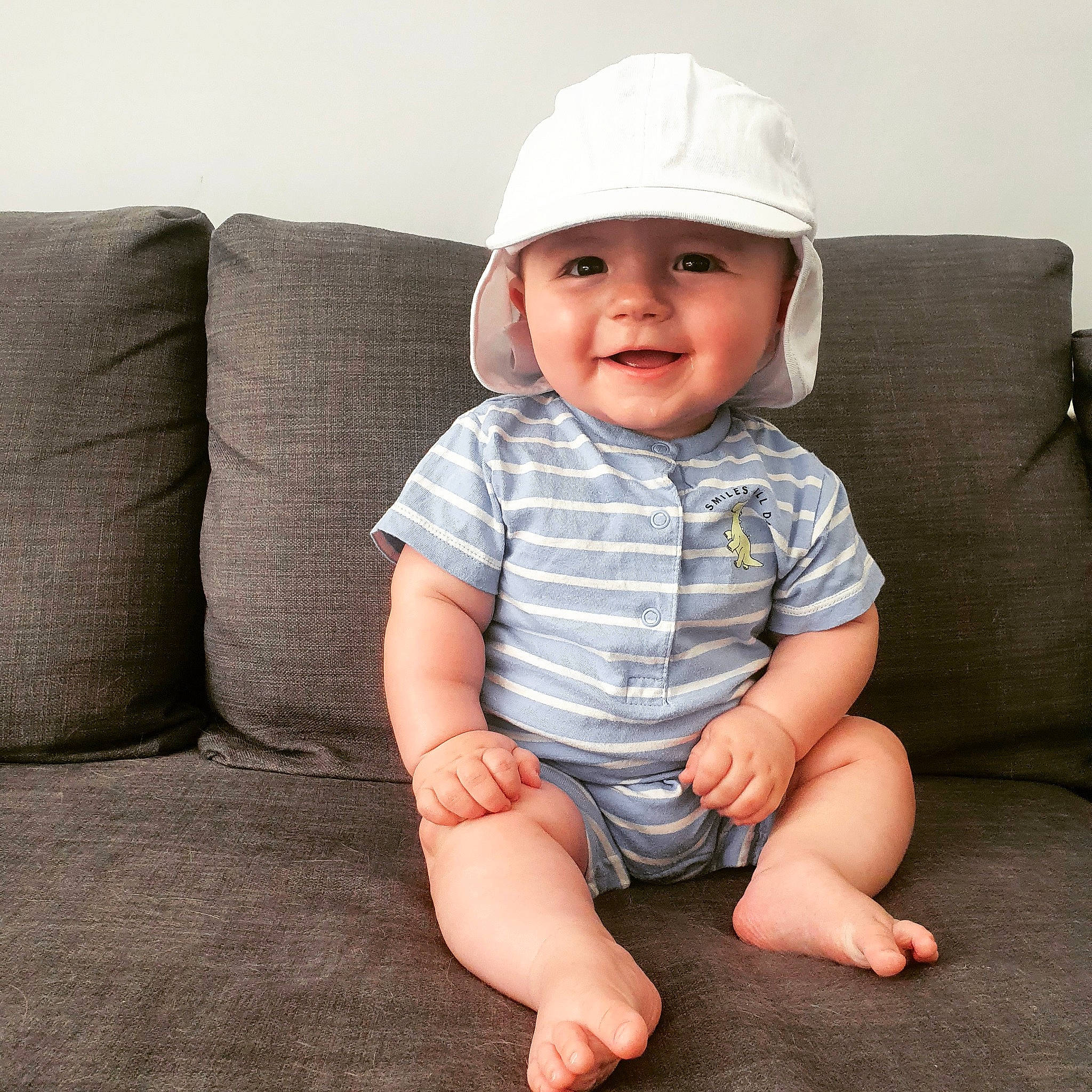 Oliver is registered to the contest to win money with this photo: baby, baby_toddler_clothing, cap, child, comfort, couch, eye, face, fashion_accessory, happy, hat, head, headwear, human_leg, joy, leg, pattern, person, sitting, skin