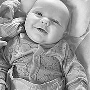 Ivar joined the competition — help win amazing prizes! baby, infant, smile, face, onesie, dog_pattern, clothing, cushion, soft_toy, portrait, happy, child, cute, indoors, closeup, newborn, comfort, resting, black_and_white, expression