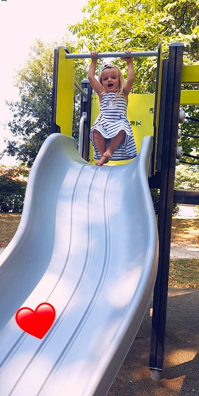 Haïvy participe au concours pour gagner de l'argent avec cette photo : baby_toddler_clothing, chute, city, fun, grass, leisure, outdoor_play_equipment, outdoor_recreation, person, photograph, plant, play, playground, playground_slide, public_space, recreation, shorts, toddler, tree, white