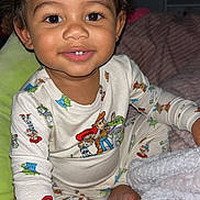 Christopher joined the competition — help win amazing prizes! toddler, child, smiling, portrait, sitting, pajamas, cartoon, toy_story, blanket, bed, pillow, bedroom, indoors, curly_hair, brown_eyes, happy, cozy, baby, flash_photography, close_up